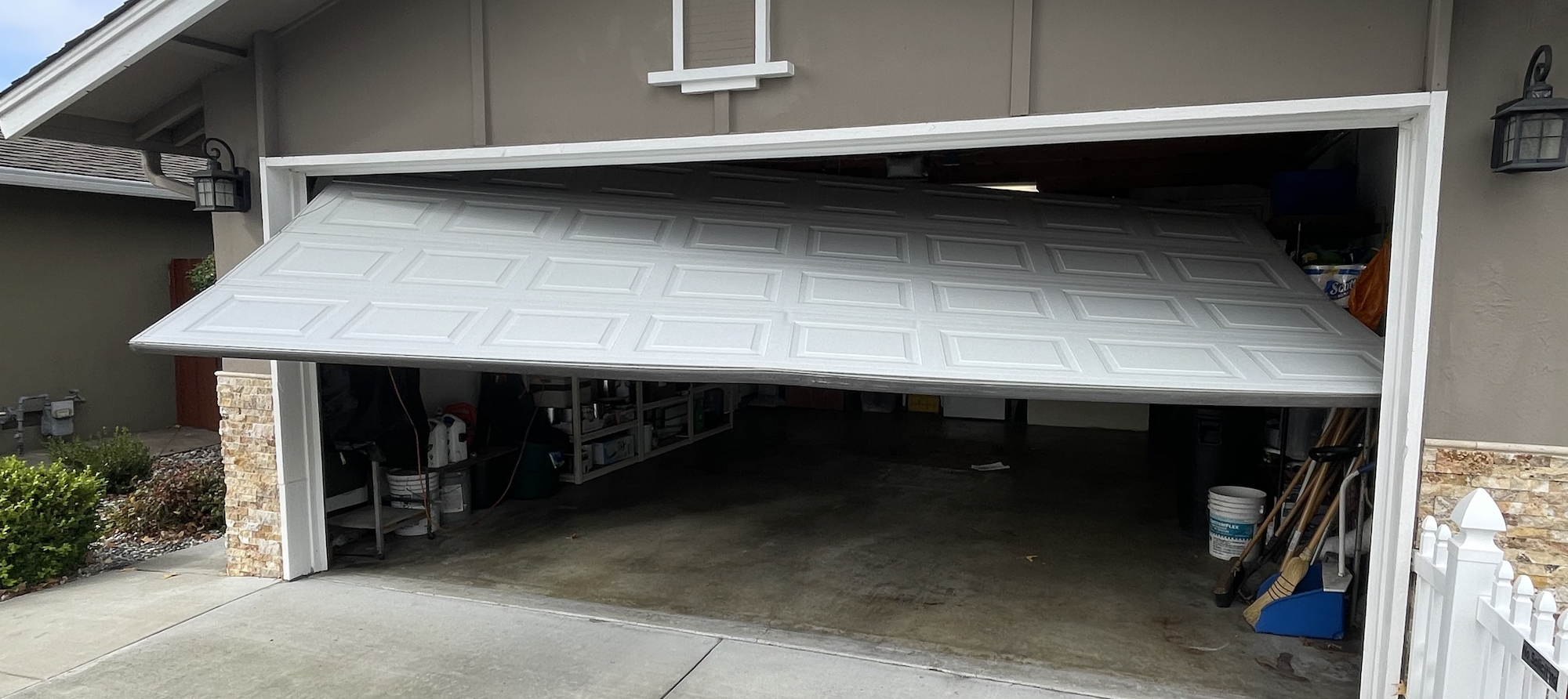 Garage door hanging crooked after coming off its track